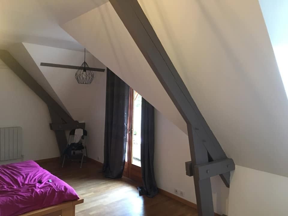 Chambre sous combles rénovée : murs blancs, poutres repeintes en gris