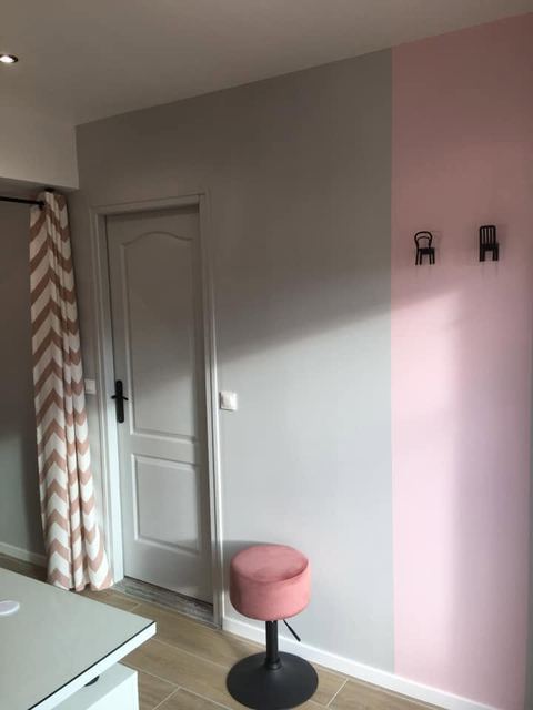 Après : mur gris et rose, porte et rideau vers l'arrière-boutique