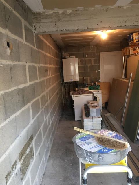 Avant : garage aux murs en parpaings, chaudière au fond
