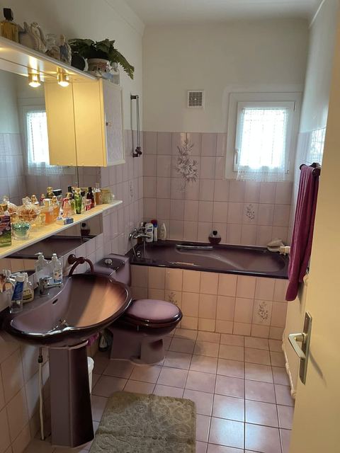 Salle de bain avant travaux : sanitaires violets, faïence rose à fleurs
